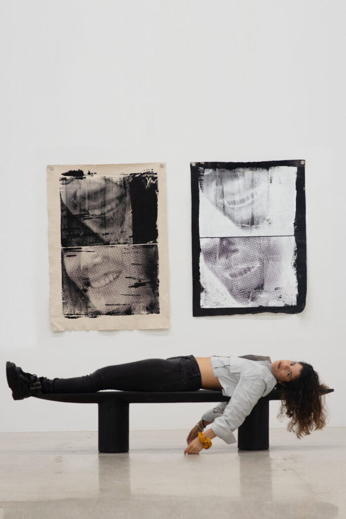 woman laying on a banch beneath two black and white pictures of smiles