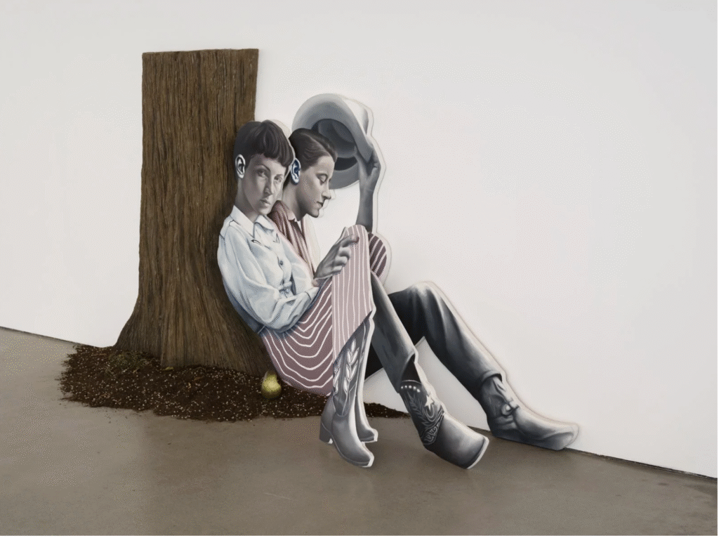 two people sitting inder a tree cut out with a pear next to them